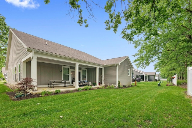 rear view of property featuring a lawn and a patio