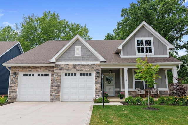 craftsman-style home with a porch, a garage, and a front yard