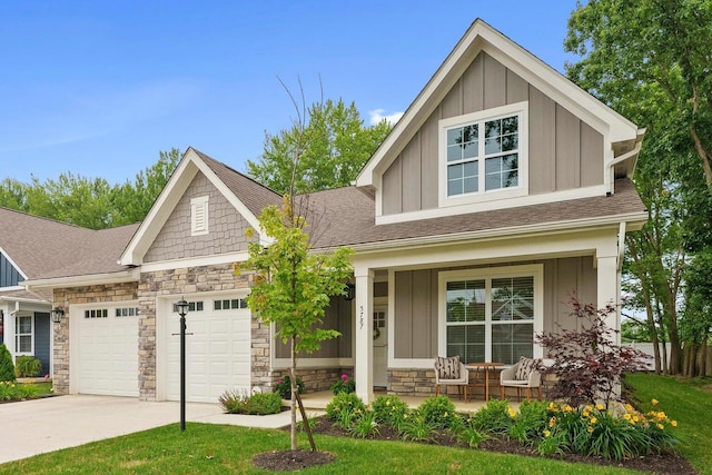 craftsman inspired home featuring covered porch and a garage