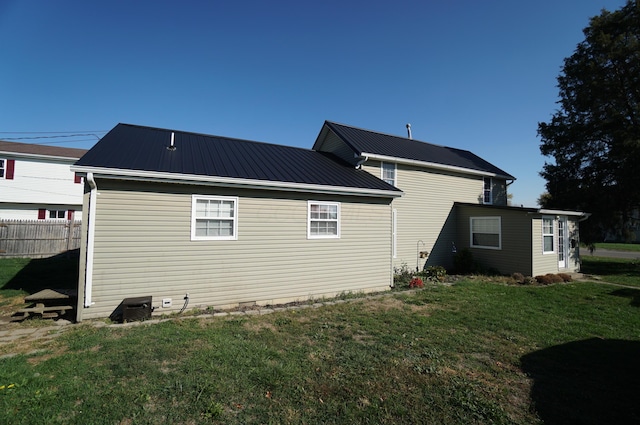 rear view of house featuring a lawn