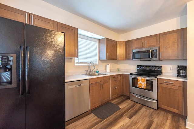 kitchen featuring stainless steel appliances, dark hardwood / wood-style floors, and sink