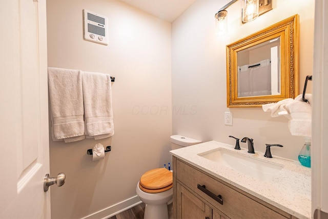 bathroom featuring toilet, vanity, and hardwood / wood-style flooring