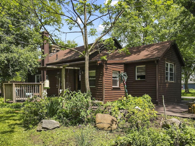 view of front of home featuring a chimney and a wooden deck