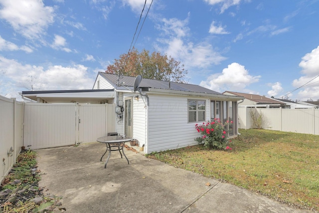 back of house featuring a lawn and a patio