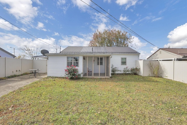 rear view of house with a lawn and a patio