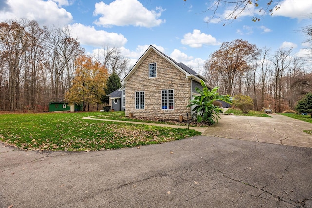 view of home's exterior with a storage shed and a lawn