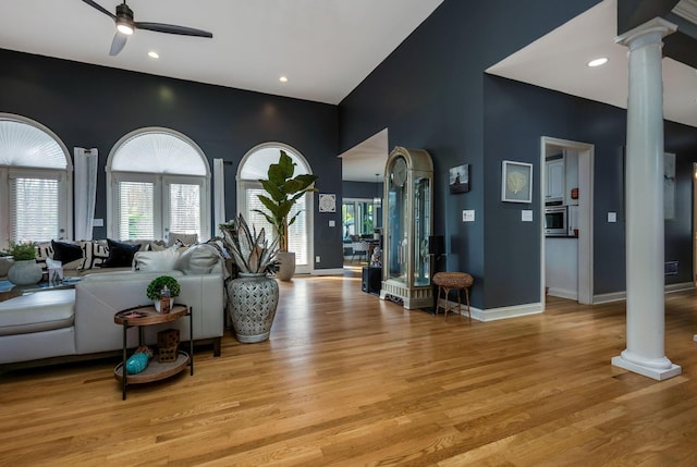 living room featuring ornate columns, ceiling fan, and light hardwood / wood-style flooring