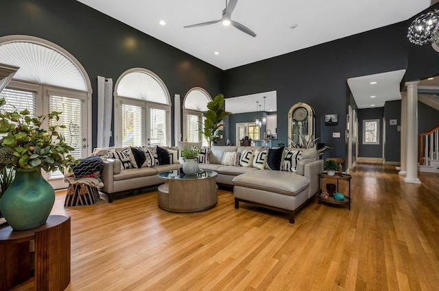 living room featuring light hardwood / wood-style flooring, ceiling fan, and ornate columns