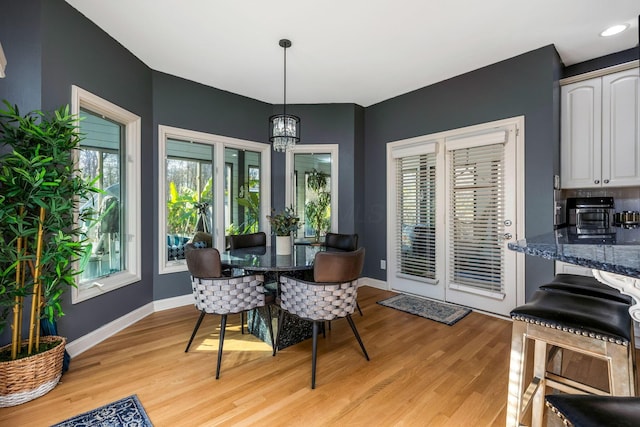 dining space with an inviting chandelier and light hardwood / wood-style flooring