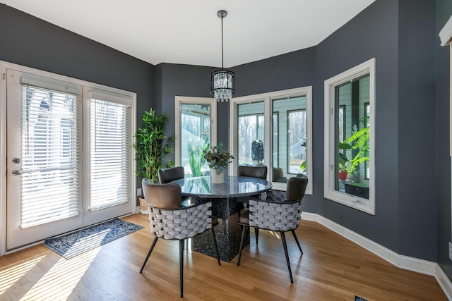 dining area featuring hardwood / wood-style floors and an inviting chandelier