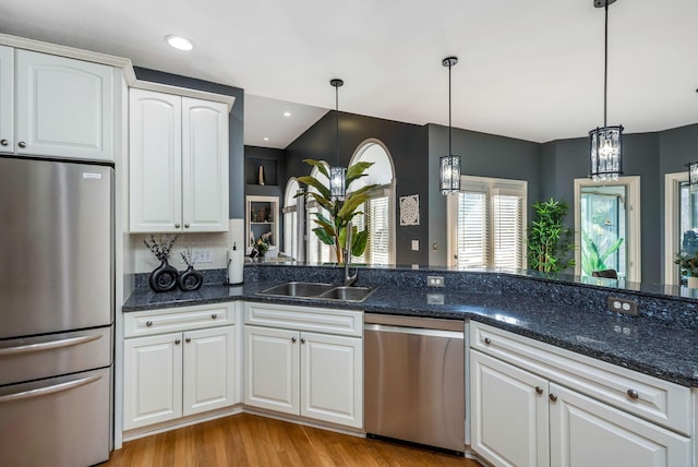 kitchen with white cabinetry, sink, pendant lighting, appliances with stainless steel finishes, and light wood-type flooring