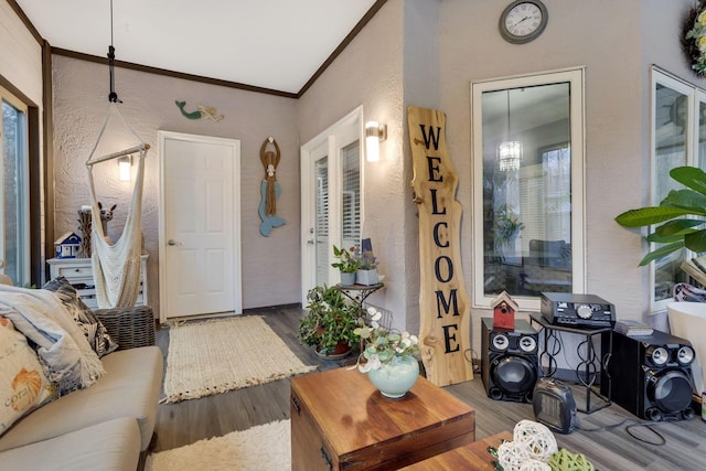 living room featuring wood-type flooring, a wealth of natural light, and crown molding