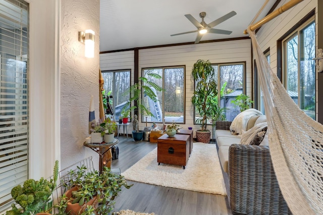 sunroom / solarium with ceiling fan, plenty of natural light, and lofted ceiling