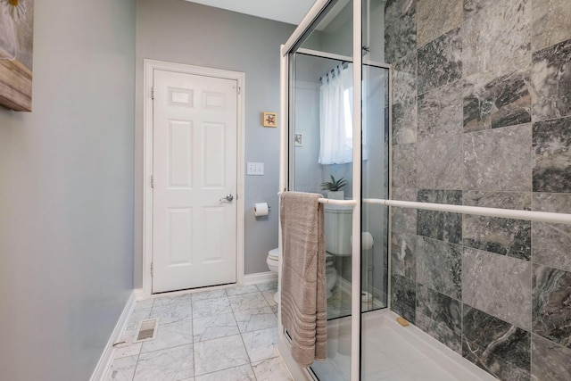 bathroom with a shower with door and toilet