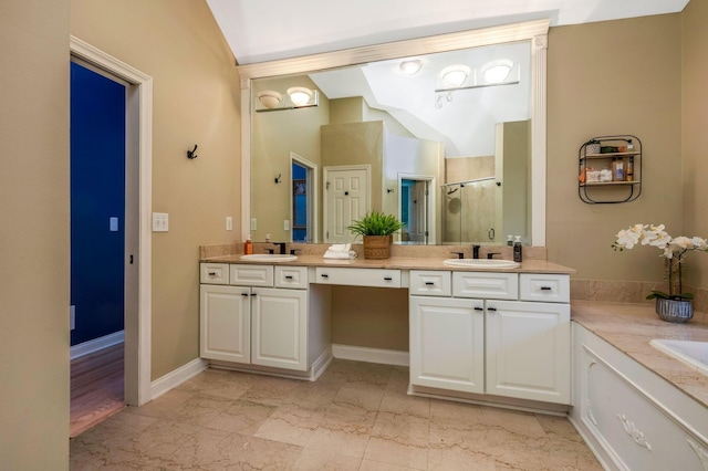 bathroom featuring a shower with door, vanity, and vaulted ceiling