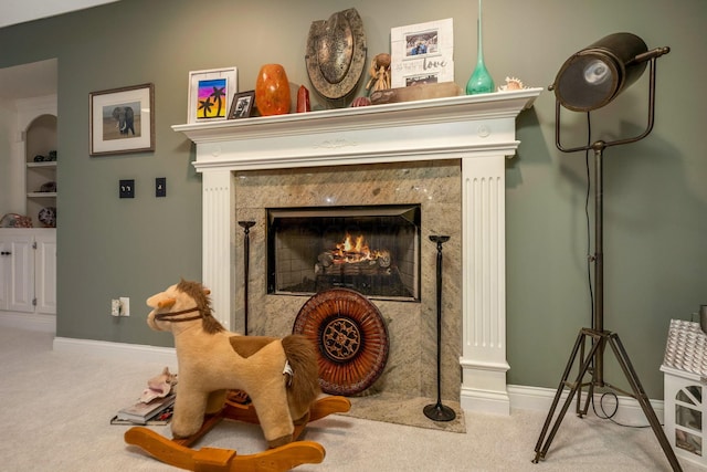 sitting room featuring carpet floors and a high end fireplace