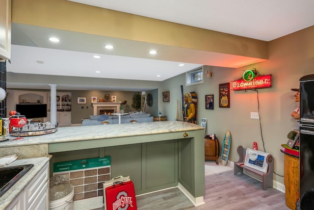 kitchen featuring green cabinets, light hardwood / wood-style flooring, and sink