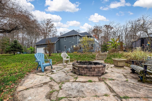 view of patio with a garage and an outdoor fire pit