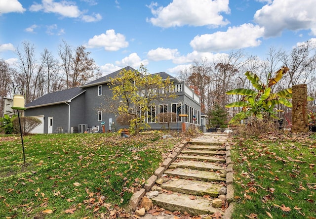 back of house with a sunroom and a lawn