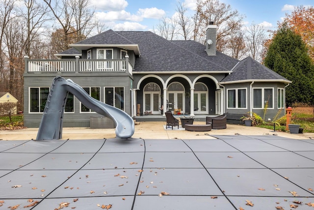 rear view of house featuring an outdoor hangout area, a balcony, and a patio area