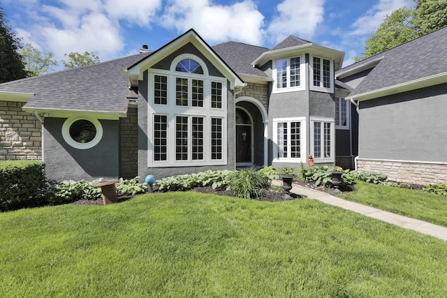 6003 Nichols Ln, Johnstown, OH 43031 - view of front of home with stucco siding, a front lawn, stone siding, and a shingled roof