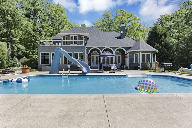 6003 Nichols Ln, Johnstown, OH 43031 - outdoor pool featuring a water slide, a patio, and view of wooded area