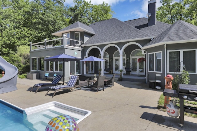 6003 Nichols Ln, Johnstown, OH 43031 - rear view of house with a balcony, a shingled roof, a patio area, and an outdoor pool