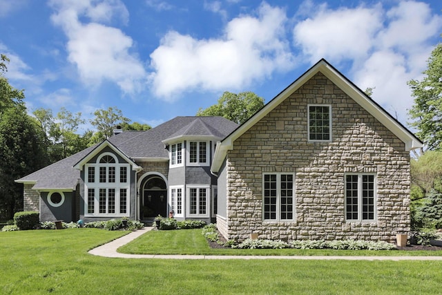 6003 Nichols Ln, Johnstown, OH 43031 - view of front of house with stone siding, a front yard, and roof with shingles