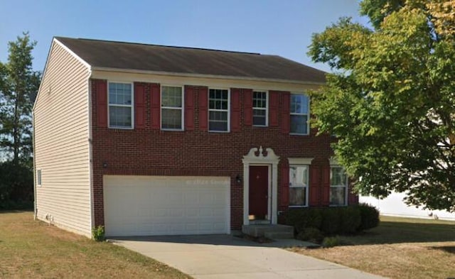 colonial inspired home with a front yard and a garage