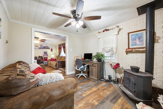 office with dark hardwood / wood-style flooring, ornamental molding, brick wall, ceiling fan, and a wood stove