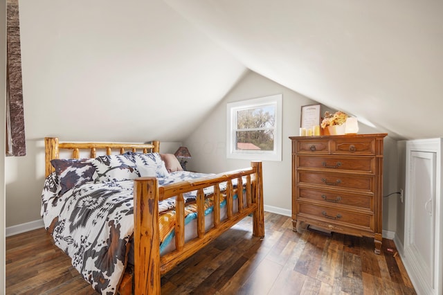 bedroom with dark hardwood / wood-style floors and lofted ceiling