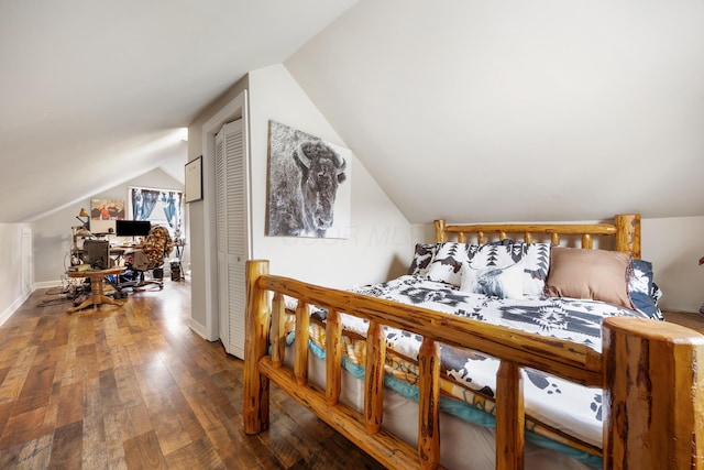 bedroom with hardwood / wood-style floors, a closet, and vaulted ceiling