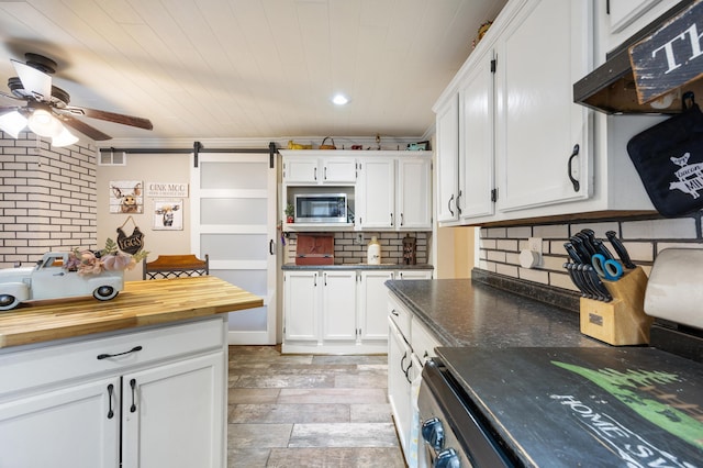 kitchen with white cabinets, stainless steel microwave, and ornamental molding