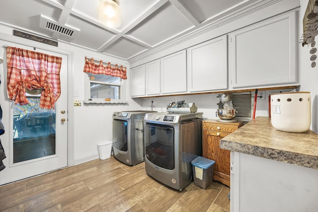 washroom featuring washer and clothes dryer, cabinets, and light hardwood / wood-style floors