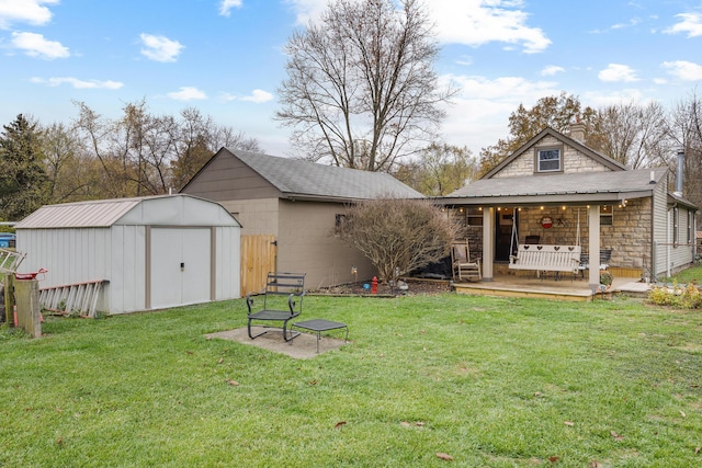 rear view of house featuring a yard and a shed