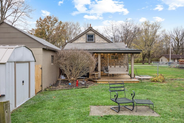 back of house with a wooden deck, a yard, and a storage unit