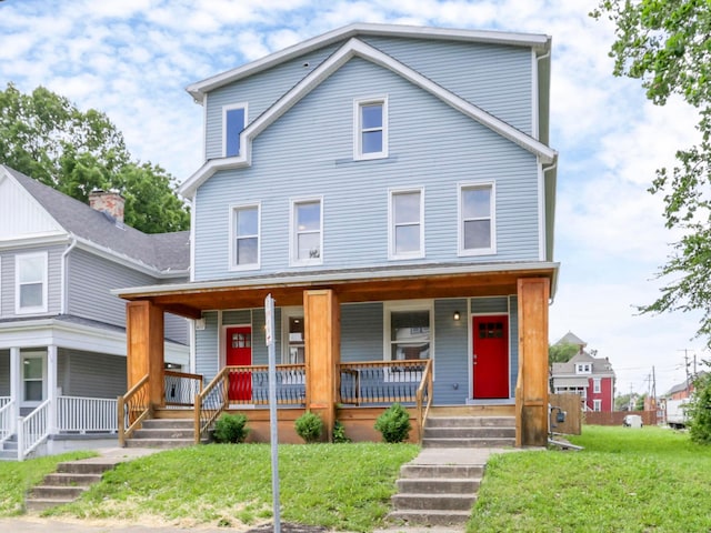 view of front of home with covered porch and a front lawn