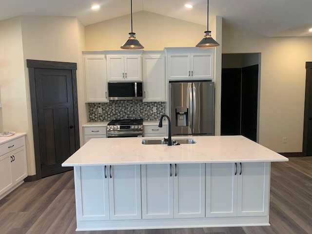 kitchen featuring pendant lighting, lofted ceiling, sink, appliances with stainless steel finishes, and light stone counters