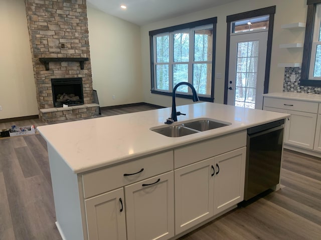 kitchen featuring dishwasher, dark hardwood / wood-style floors, a center island with sink, and sink