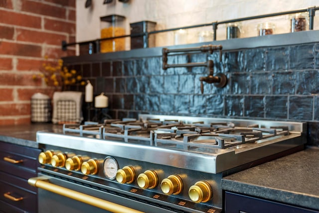 kitchen with high end stainless steel range and brick wall