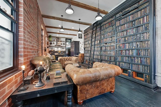 interior space with beamed ceiling, dark hardwood / wood-style flooring, and brick wall