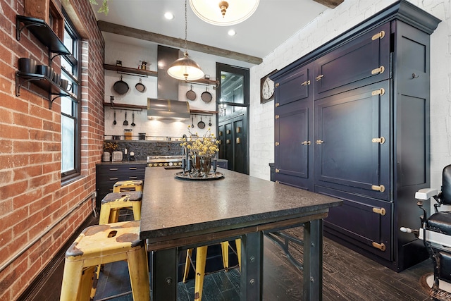 interior space with pendant lighting, blue cabinets, and brick wall