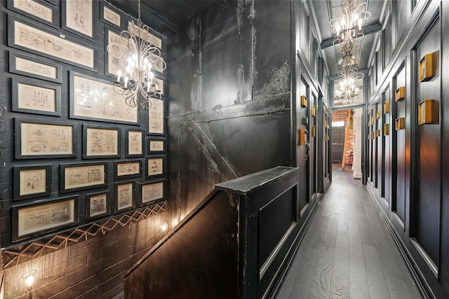 corridor with an inviting chandelier and hardwood / wood-style flooring