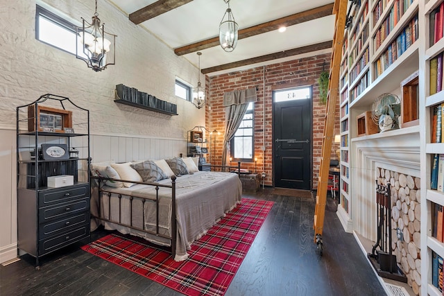 bedroom with dark hardwood / wood-style flooring, beamed ceiling, and brick wall