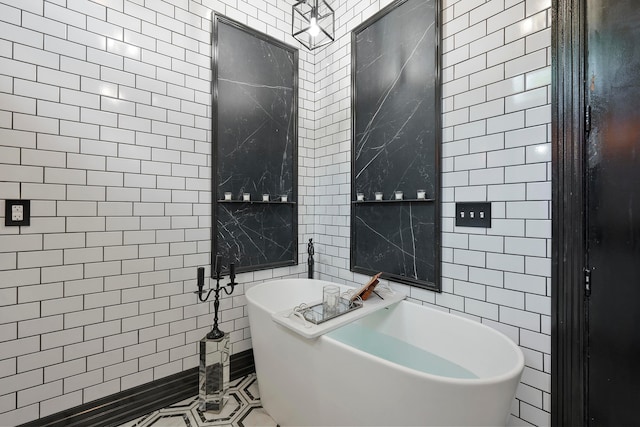 bathroom featuring a tub to relax in, tile patterned floors, and tile walls