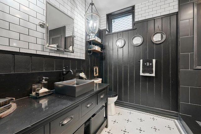 bathroom with tile patterned flooring, backsplash, toilet, and tile walls