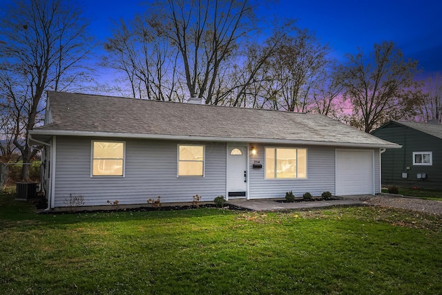 ranch-style house with a yard, a garage, and central air condition unit