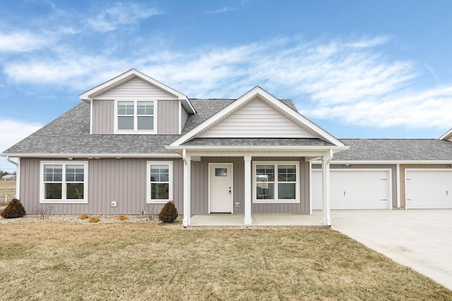 view of front of house featuring a porch, a garage, and a front yard