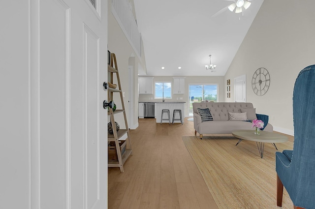 110 Cumberland Meadows Cir, Hebron, OH 43025 - living room with light wood-style floors, a chandelier, a ceiling fan, baseboards, and high vaulted ceiling