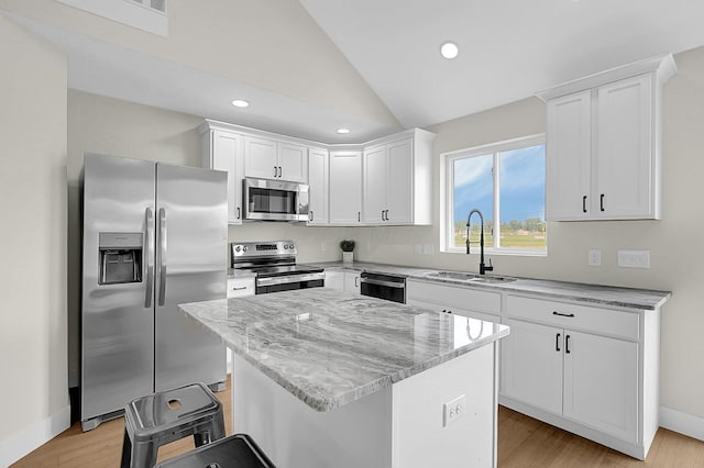 110 Cumberland Meadows Cir, Hebron, OH 43025 - kitchen with stainless steel appliances, a sink, a kitchen island, light stone countertops, and lofted ceiling